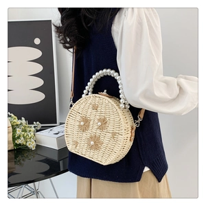 Détail du sac bandoulière en paille tissé main avec poignée en perles et fleurs