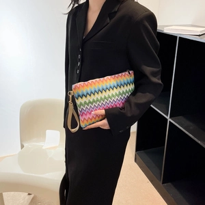 Close-up of rainbow crochet clutch with colorful zigzag pattern and leather wristlet