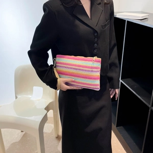 Close-up of rainbow striped woven clutch bag with metal zipper and wristlet strap