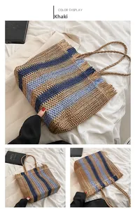 Dettaglio della borsa in paglia a righe cachi e blu con frange e doppi manici intrecciati