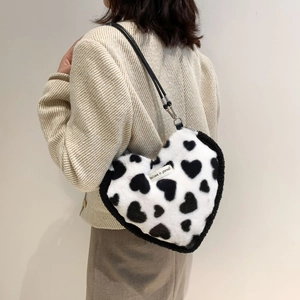 Detail view of heart-shaped faux fur shoulder bag with black and white spotted pattern