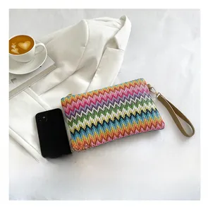 Detailed macro view of rainbow zigzag woven clutch with leather strap and metal zipper