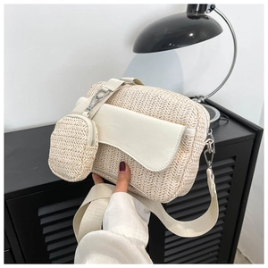 Detail of summer woven crossbody bag with white leather flap and small coin purse attachment