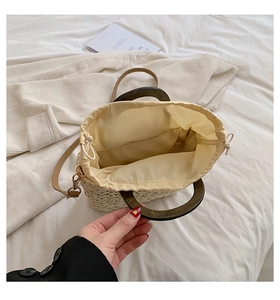 Straw handbag with wooden ring handles and drawstring lining shown from top view