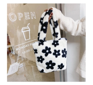 Détail de la texture en peluche douce et du motif floral noir sur le sac en fourrure