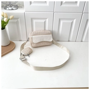 Detail of woven crossbody bag in beige with matching mini pouch and adjustable wide strap