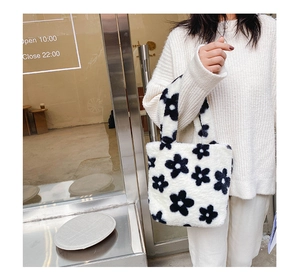 Vue détaillée du sac à main en peluche à motif floral noir et blanc porté par un mannequin