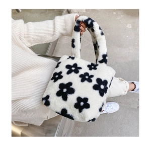 Gros plan du sac en peluche blanche avec motifs floraux noirs et texture douce