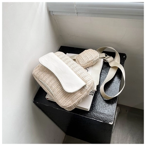 Detail of cream woven crossbody bag featuring a round coin purse and wide fabric strap
