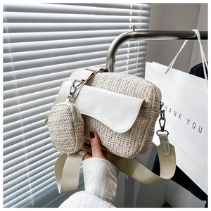 Close-up of cream woven crossbody bag with round coin purse and wide strap detail