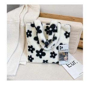 Gros plan d'un sac cabas en fausse fourrure avec motif floral sur fond en tricot chaud