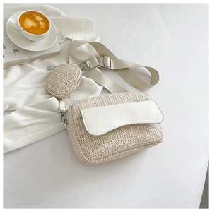 Detail of woven crossbody bag with mini pouch on a wide strap and cream textured flap
