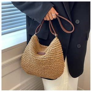 Détail de la texture en paille tressée à la main et de la bandoulière en cuir marron foncé