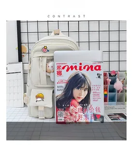 Size comparison of beige student backpack with transparent pocket and plush doll accessory