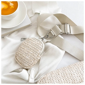 Detail of beige woven crossbody bag featuring herringbone texture and silver hardware
