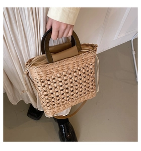 Detail of straw handbag with wooden handle, drawstring lining and leather shoulder strap