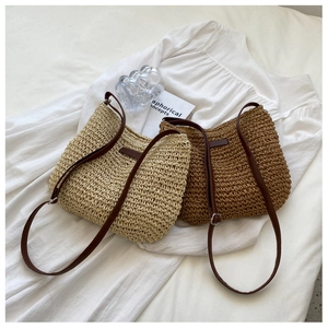 Detailed close-up of beige and brown woven straw shoulder bags with leather straps