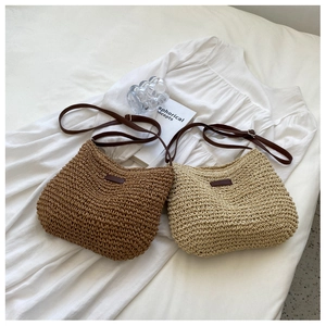 Détail de sacs à bandoulière en paille tissée marron et beige avec sangle en cuir