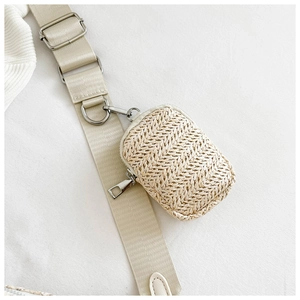 Detail of woven straw mini pouch bag with silver zipper and canvas shoulder strap