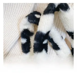 Détail de la poignée en fausse fourrure avec un motif de vache noir et blanc
