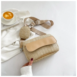 Detail of straw crossbody bag with leather flap, woven texture and small round coin purse