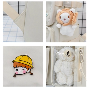 Detail view of beige school backpack with transparent window and cute plush bear accessory