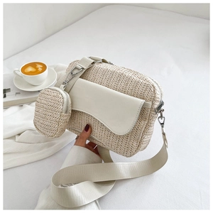 Detail of woven beige crossbody bag with a mini round coin purse on wide shoulder strap
