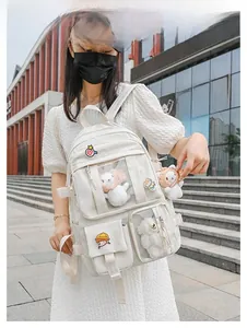 Detail showing white Japanese style backpack with clear front pockets and cute plush toys