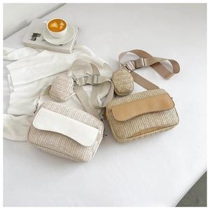 Detail view of woven straw crossbody bag with leather flap and adjustable wide nylon strap