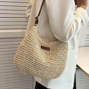 Chic sac à bandoulière en paille tissée avec sangle en cuir porté par un mannequin en été