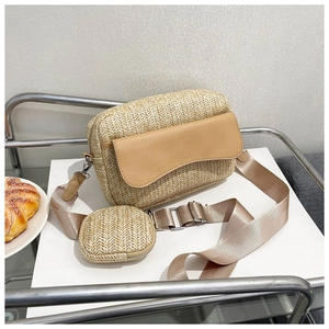 Detail view of woven straw crossbody bag with khaki leather flap and mini round pouch