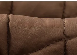 Vue macro du tissu matelassé marron avec surpiqûres en losanges et texture soyeuse