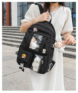 Detail of black ita bag with clear windows displaying plush toys and cute badges