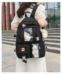 Close-up of black Japanese style backpack with transparent window displaying plush toys