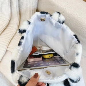 Sac sous le bras en peluche à motif vache montrant l'intérieur spacieux et pratique