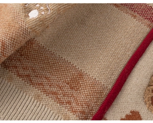 Close-up of winter knit sweater showing thick texture, khaki stripes, and cute embroidery