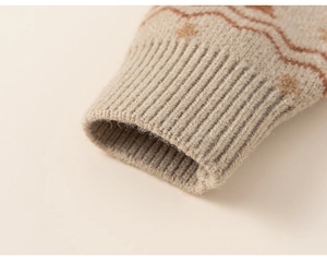 Detailed macro view of the soft ribbed cuffs and orange geometric star knit pattern