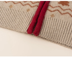 Detailed macro view of beige knit fabric with festive red Christmas tree and wave patterns