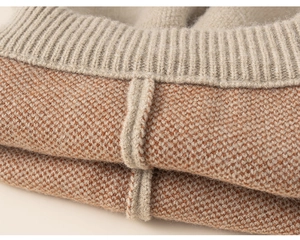 Macro view showing the detailed knit texture and ribbed edge of the girls' orange sweater