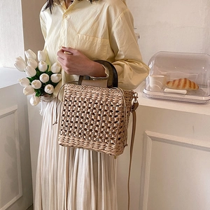 Chic woven straw handbag with dark wood handles and leather straps for modern women