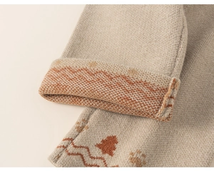 Detailed macro view of beige knit fabric with orange jacquard tree patterns and texture