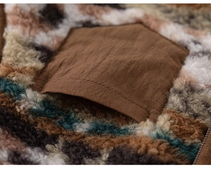 Détail macro du gilet en peluche pour enfants avec motif léopard et poche plaquée marron