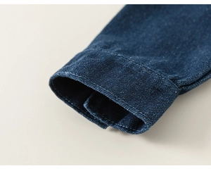 Detailaufnahme der Jeans-Manschette mit sauberen Nähten am Mädchen-Jeanshemd