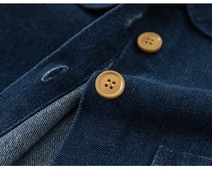 Detailansicht der dunkelblauen Denim-Textur und der gelben Vierlochknöpfe aus der Nähe