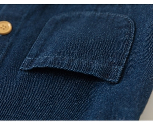 Detaillierte Makroansicht der Nähte und Knöpfe an einem Denim-Hemd für kleine Mädchen