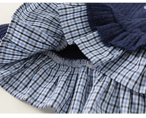 Detail of navy knit fabric stitched with blue ruffled plaid hem for girls clothing