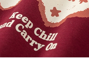 Detail van rode sweatshirt katoenen textuur met witte sterrenprint en chill slogan