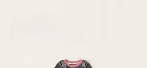 Close-up detail of girls long-sleeve knit shirt with pink patchwork neckline