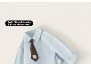 Detail of blue boys shirt with brown necktie featuring small bear embroidery