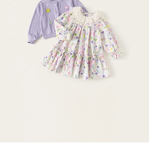 Detail of floral girls' dress with lace collar and purple knit cardigan flat lay